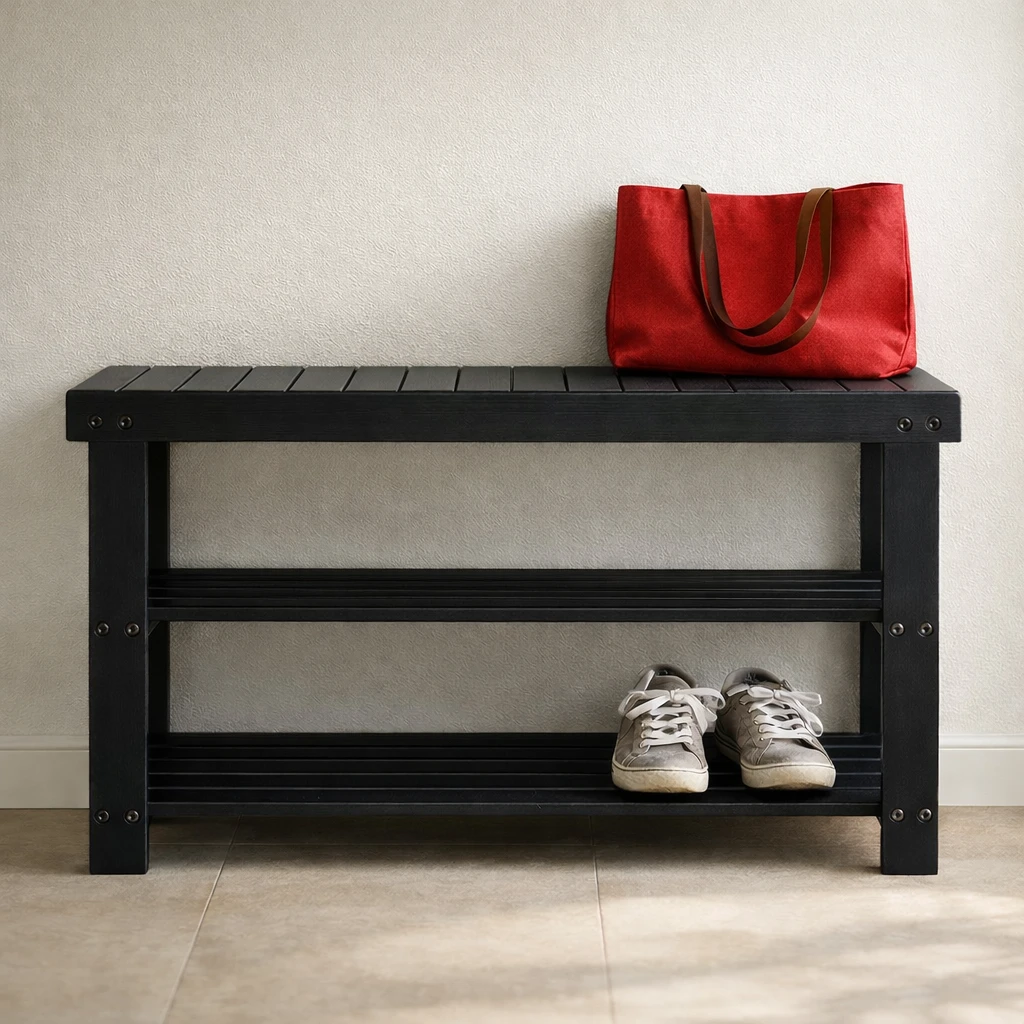 Black bamboo shoe rack bench in an entryway, shown front-facing with one pair of sneakers on the lower shelf and a red tote bag resting on top.